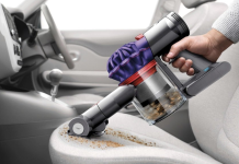 Moc ssania, czas pracy, pojemność – na co patrzeć, wybierając bezprzewodowy odkurzacz samochodowy? mężczyzna odkurza tapicerkę fotela samochodu czarnym bezprzewodowym odkurzaczem w garażu