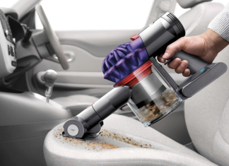 Moc ssania, czas pracy, pojemność – na co patrzeć, wybierając bezprzewodowy odkurzacz samochodowy? mężczyzna odkurza tapicerkę fotela samochodu czarnym bezprzewodowym odkurzaczem w garażu