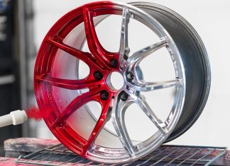 Malowanie felg proszkowo – czym różni się od klasycznego lakierowania i dlaczego daje trwalszy efekt? nowe błyszczące czarne felgi aluminiowe obok starych matowych na stole warsztatowym
